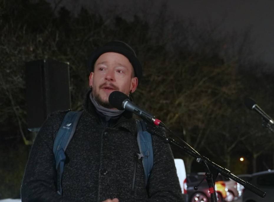 Das Foto zeigt Robert Kosin, wie er auf der Demonstration in ein Mikrofon spricht.
