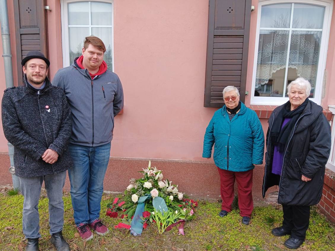 Das Foto ziegt vier Personen im Gedenken an das ehemalige Armenhaus in Großbeeren.