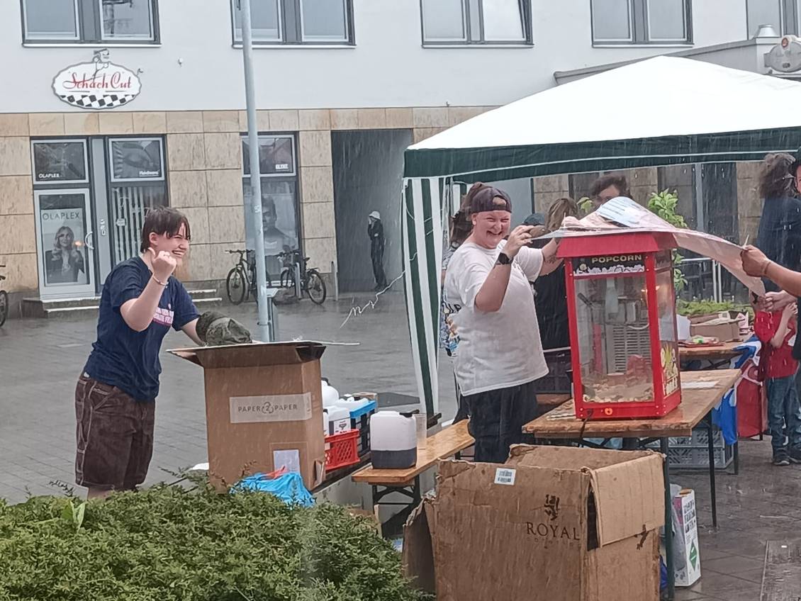 Das Foto zeigt Personen während eines Regenschauers.