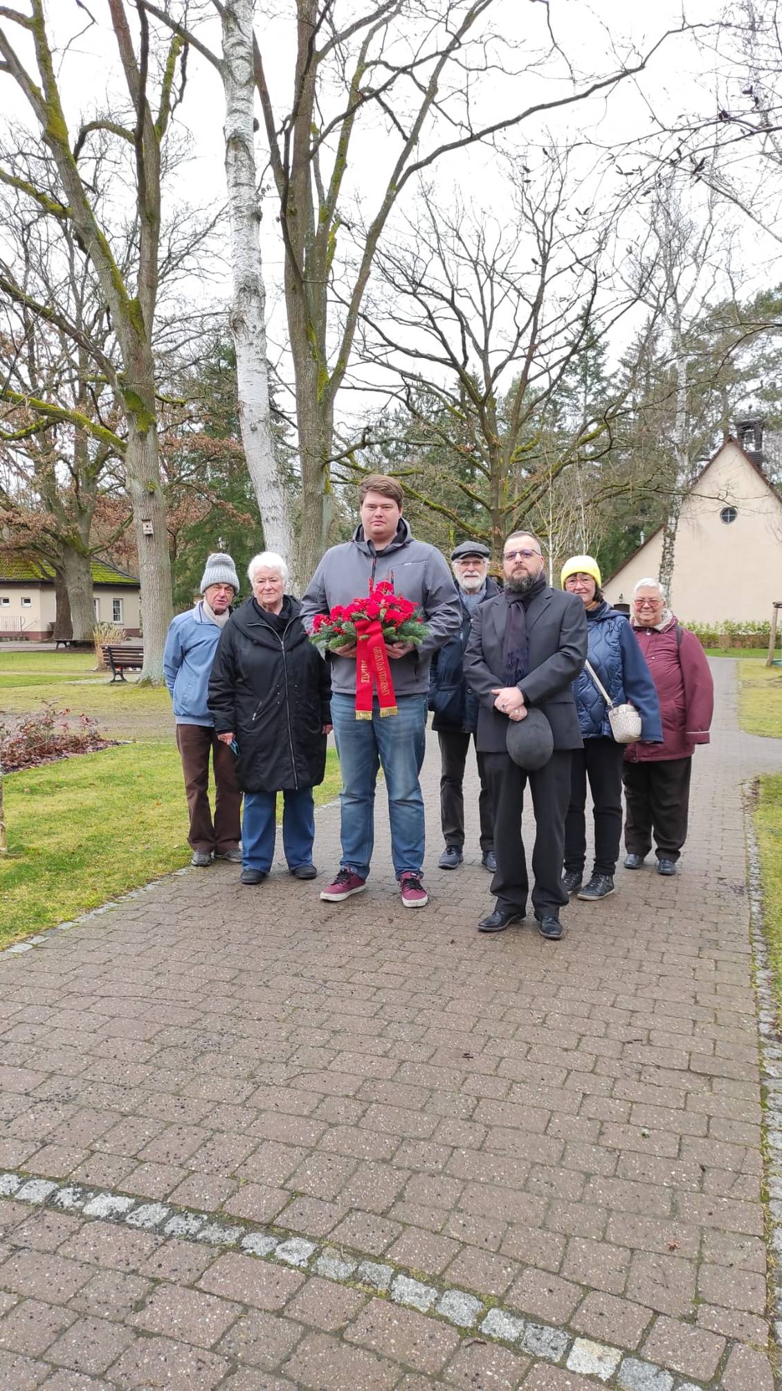 Das Foto zeigt eine Gruppe von Menschen auf dem Friedhof in Ludwigsfelde.