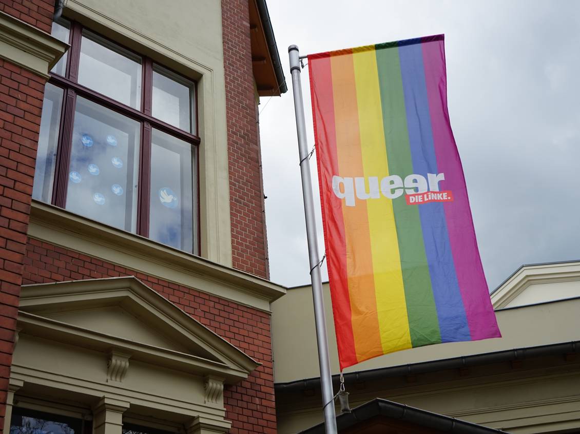 Eine Flagge in regenbogenfarben mit dem Aufdruck "queer - DIELINKE." weh am Fahnenmast vor dem Lothar-Bisky-Haus
