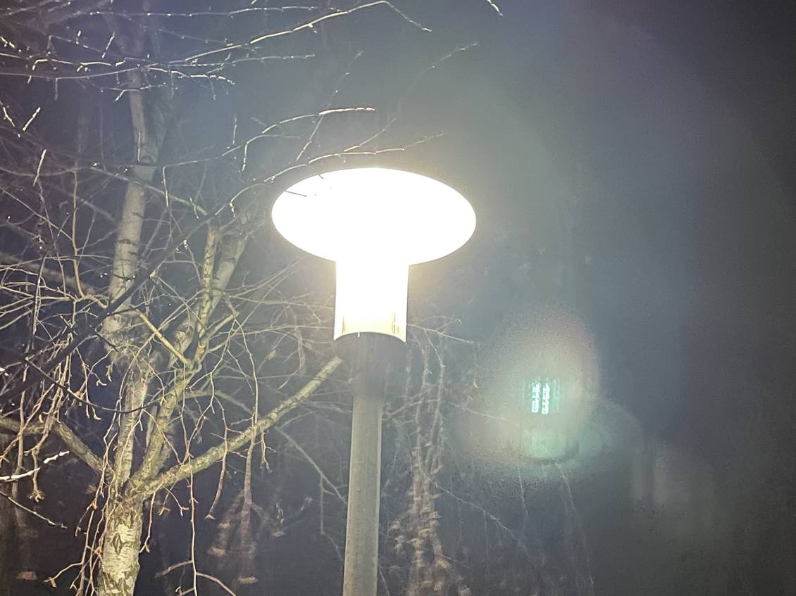 Das Foto zeigt eine leuchtende Straßenlaterne bei Nacht.